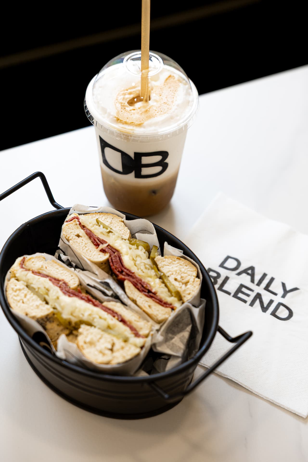 A Daily Blend bagel sandwich served with an iced coffee